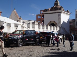 Copacabana - le baptême des voitures par le prêtre, 2 fois par jour dont le chauffeur accompagné de sa famille allume ensuite des pétards et arrose le moteur avec de la bière